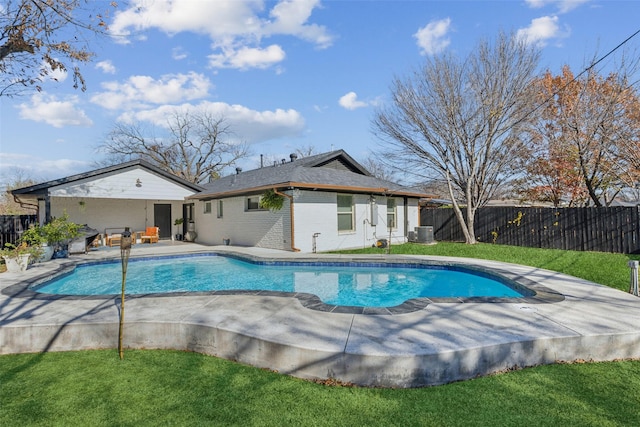 view of swimming pool with a lawn, central air condition unit, and a patio area