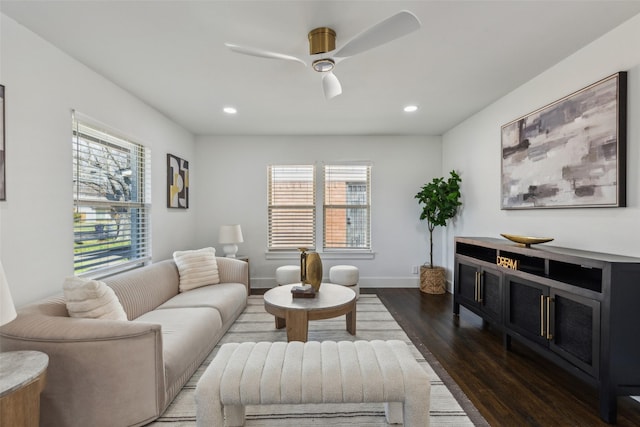 living room with ceiling fan, plenty of natural light, and dark hardwood / wood-style flooring