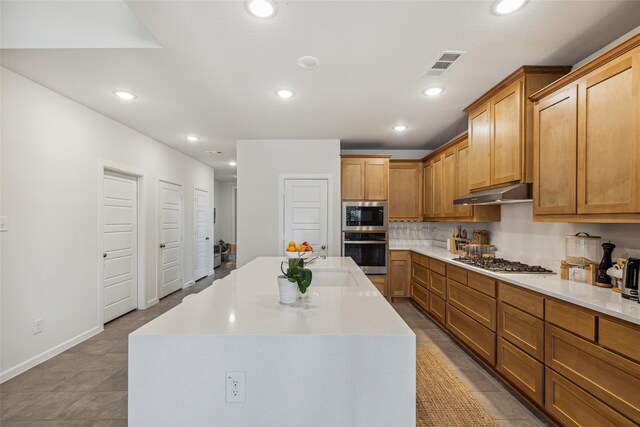 kitchen featuring a kitchen island, stainless steel appliances, light tile patterned floors, and sink