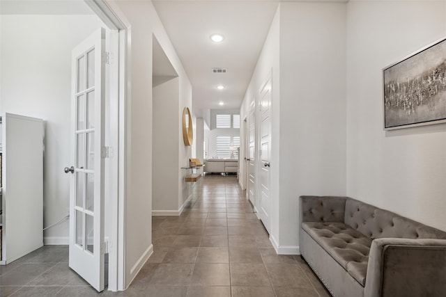 hallway with french doors and light tile patterned flooring