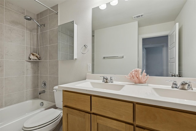 full bathroom with tiled shower / bath combo, vanity, and toilet