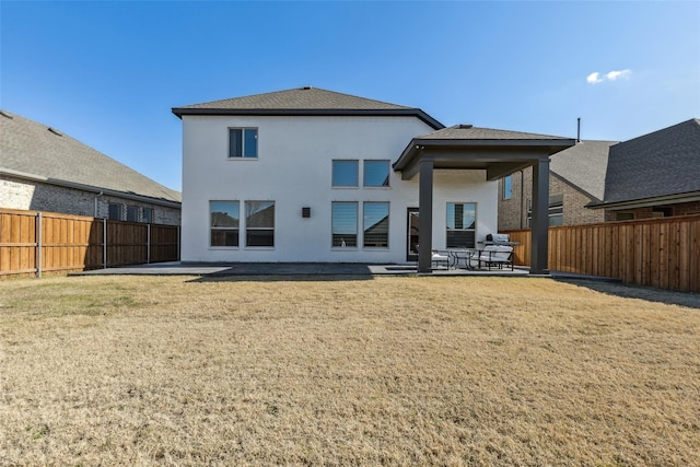 rear view of property featuring a patio area and a lawn