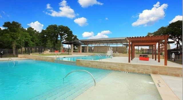 view of swimming pool featuring pool water feature, a pergola, and a patio