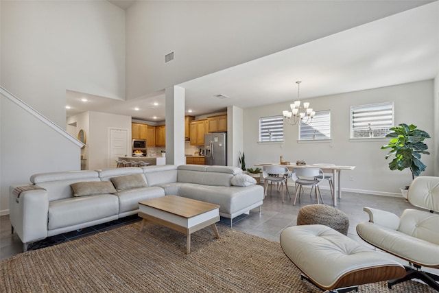 living room featuring a high ceiling, an inviting chandelier, and light tile patterned floors