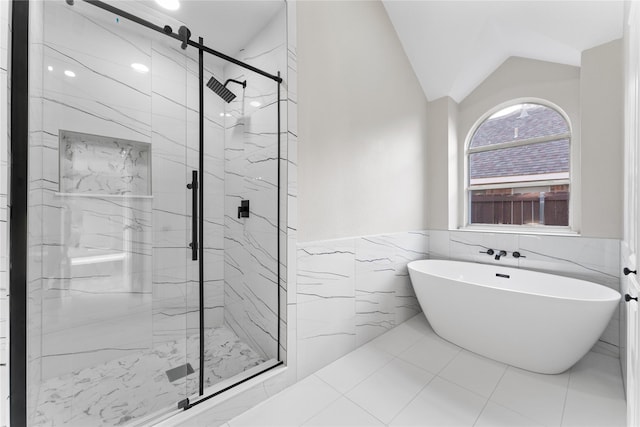 bathroom with lofted ceiling, tile walls, and plus walk in shower