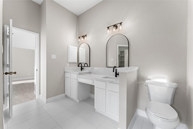 bathroom featuring toilet, vanity, and tile patterned flooring