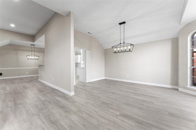 unfurnished dining area featuring vaulted ceiling and light hardwood / wood-style flooring