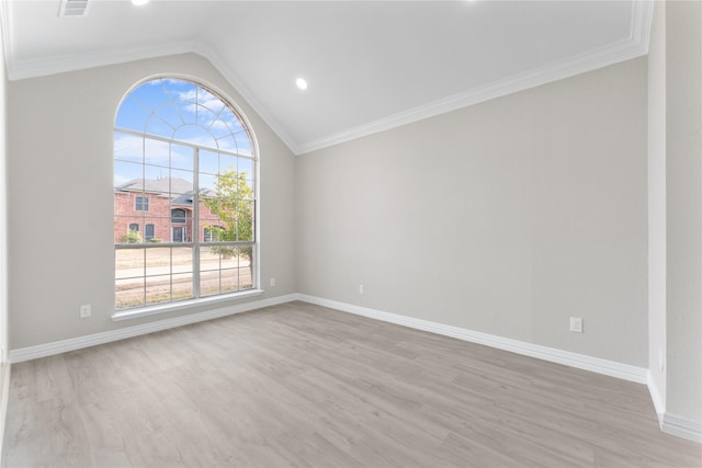 empty room featuring a wealth of natural light, vaulted ceiling, and light hardwood / wood-style flooring