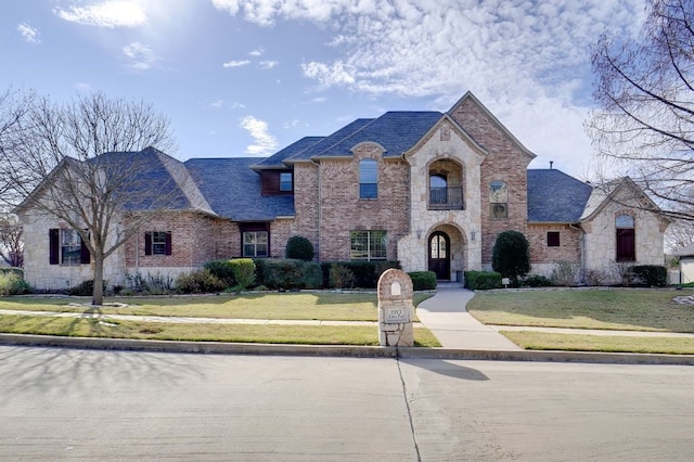 french country inspired facade featuring a front lawn