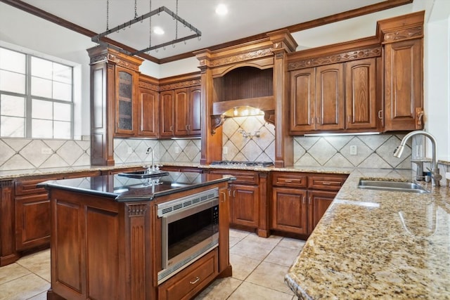 kitchen with sink, stainless steel appliances, a center island, decorative backsplash, and crown molding