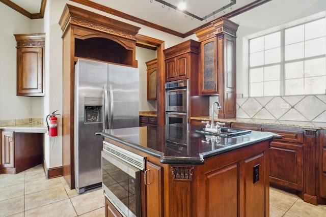 kitchen with sink, stainless steel appliances, ornamental molding, and a center island