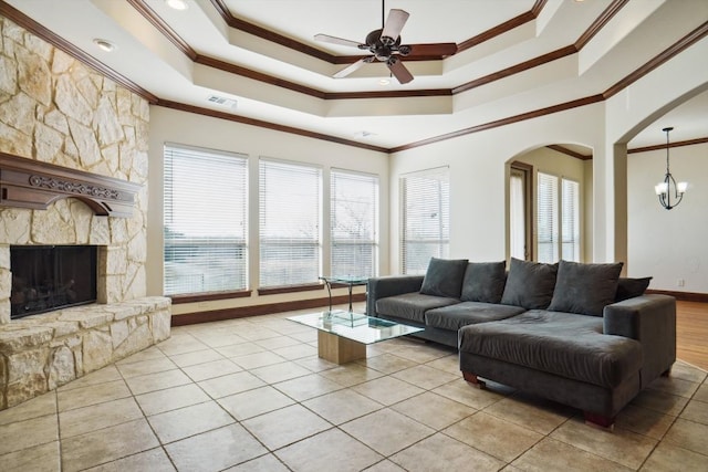 living room with a fireplace, a tray ceiling, and crown molding