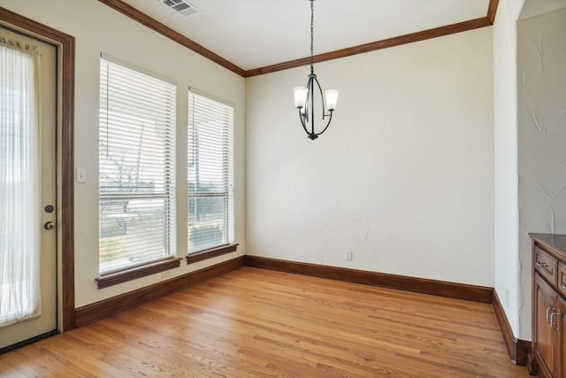 unfurnished dining area with a notable chandelier, light wood-type flooring, and ornamental molding