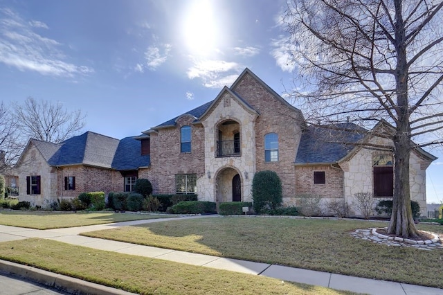 french country home featuring a front lawn