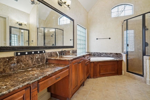 bathroom with vaulted ceiling, tile patterned floors, independent shower and bath, and vanity