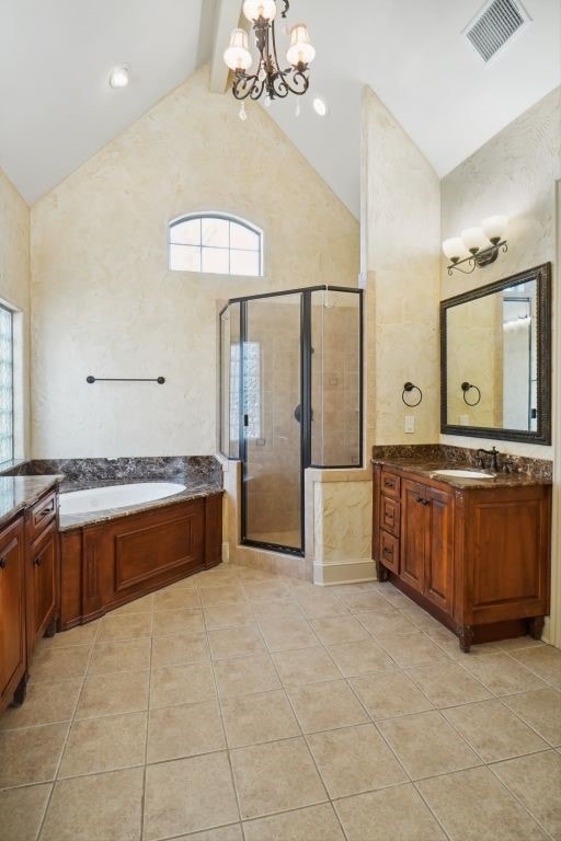 bathroom with tile patterned flooring, vanity, an inviting chandelier, and beamed ceiling