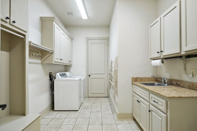 clothes washing area featuring sink, cabinets, independent washer and dryer, and light tile patterned floors