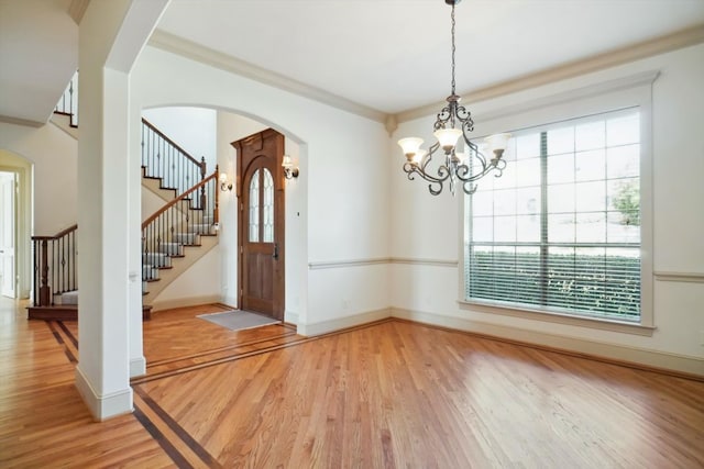 interior space featuring ornamental molding, a notable chandelier, and wood-type flooring