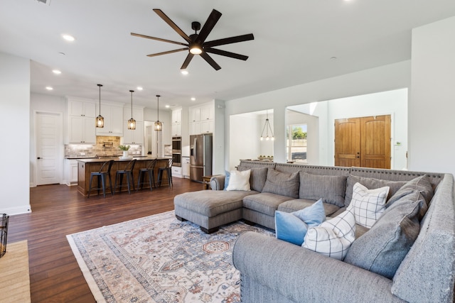 living room featuring ceiling fan and dark wood-type flooring