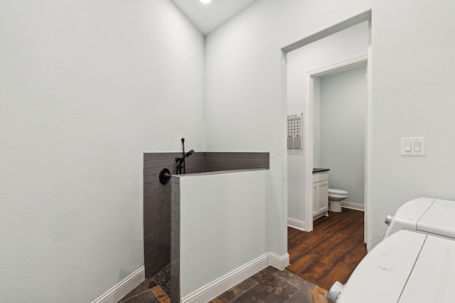 bathroom featuring vanity, washer and clothes dryer, toilet, and hardwood / wood-style floors