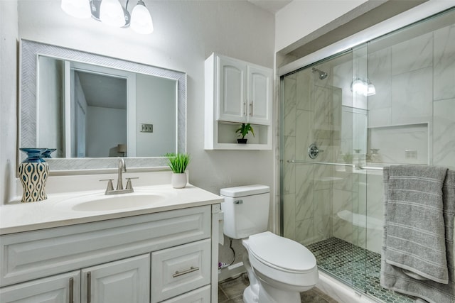 bathroom with toilet, an enclosed shower, and vanity