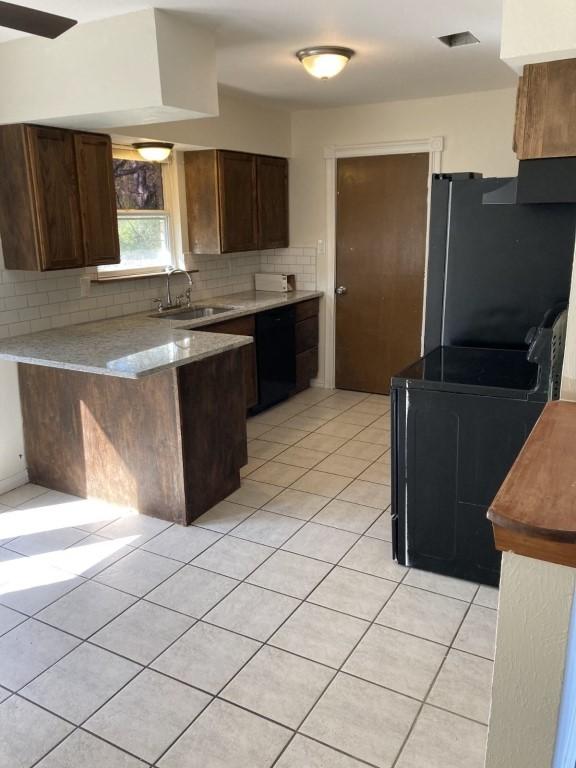 kitchen featuring tasteful backsplash, light tile patterned floors, a peninsula, black appliances, and a sink