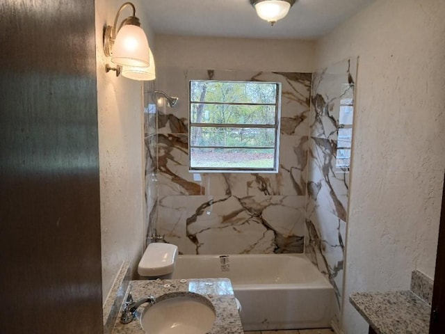 full bathroom with toilet, tiled shower / bath, and vanity