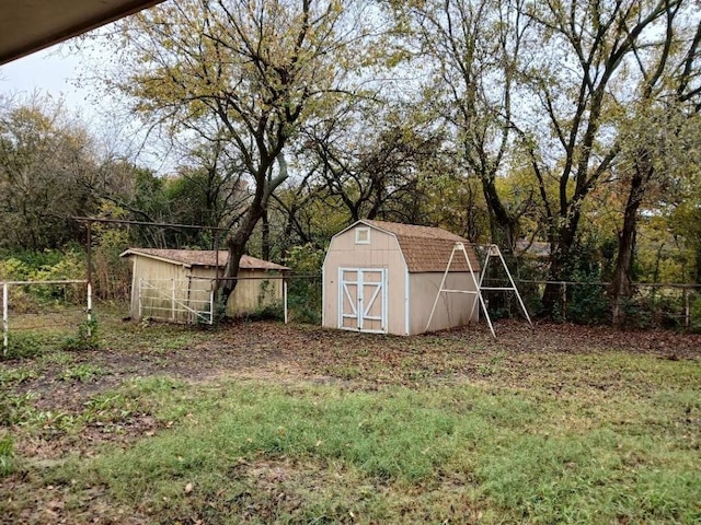 view of yard with a storage shed, an outbuilding, and fence