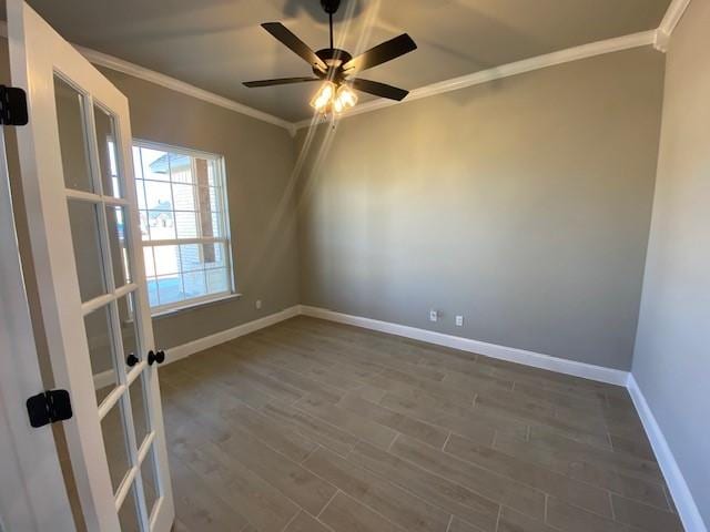 empty room with baseboards, ceiling fan, dark wood-type flooring, crown molding, and french doors