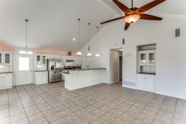 kitchen with white cabinetry, a kitchen bar, ceiling fan with notable chandelier, pendant lighting, and appliances with stainless steel finishes