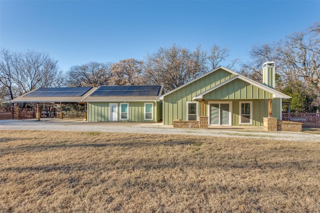 view of front of house with a front yard and solar panels