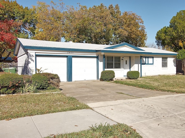 single story home featuring a front lawn and a garage