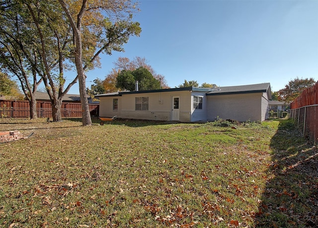 back of house featuring a lawn