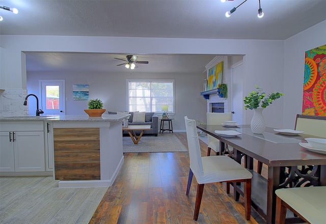 dining area featuring sink, ceiling fan, and hardwood / wood-style flooring