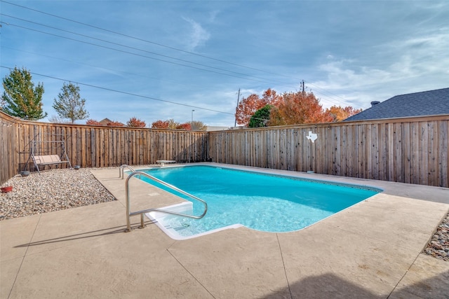 view of swimming pool with a patio area and a diving board