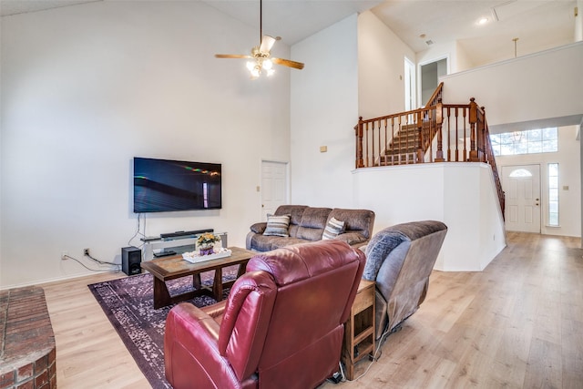 living room featuring high vaulted ceiling, light hardwood / wood-style floors, and ceiling fan