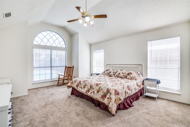 carpeted bedroom featuring ceiling fan, vaulted ceiling, and a textured ceiling