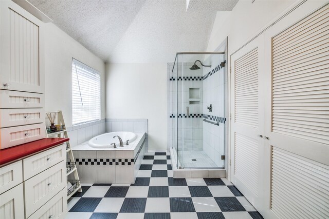 bathroom with a textured ceiling, vaulted ceiling, plus walk in shower, and vanity