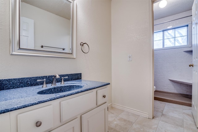 bathroom with vanity, tile patterned floors, toilet, and a textured ceiling