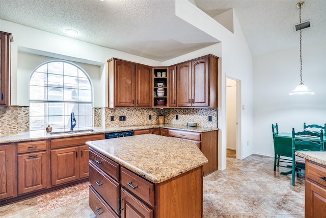 kitchen with sink, a center island, pendant lighting, light stone countertops, and decorative backsplash