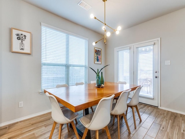 dining space featuring an inviting chandelier and light hardwood / wood-style flooring