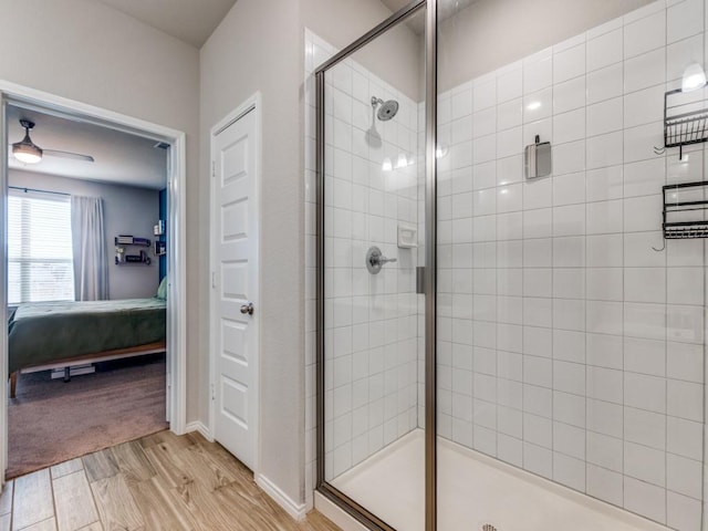 bathroom with ceiling fan, walk in shower, and hardwood / wood-style floors