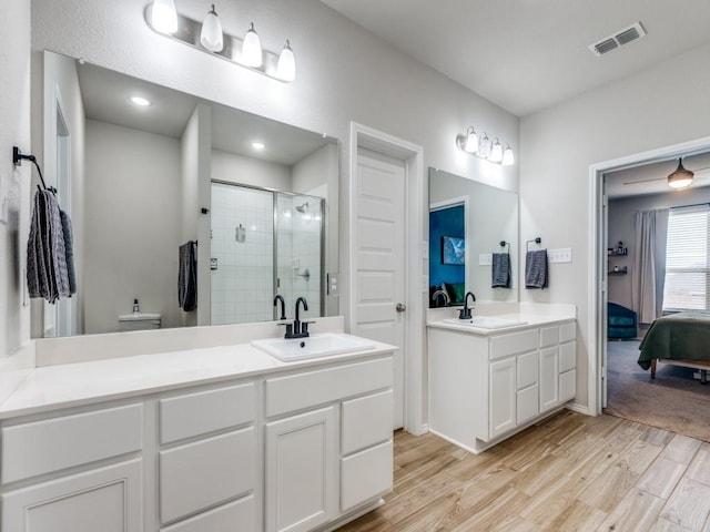 bathroom with a shower with door and vanity