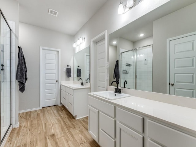 bathroom featuring an enclosed shower, vanity, and hardwood / wood-style flooring