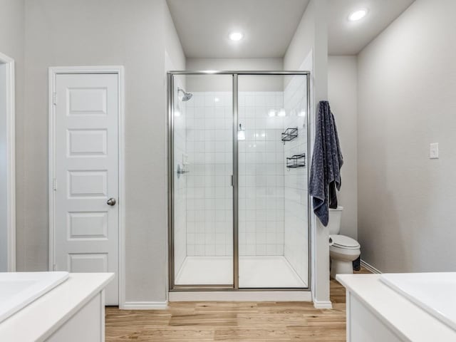 bathroom with hardwood / wood-style floors, an enclosed shower, vanity, and toilet