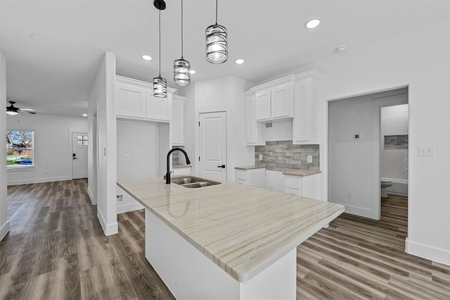 kitchen featuring a center island with sink, ceiling fan, white cabinetry, and sink