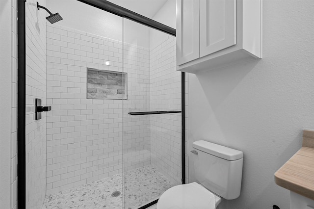 bathroom with vanity, a shower with shower door, and toilet