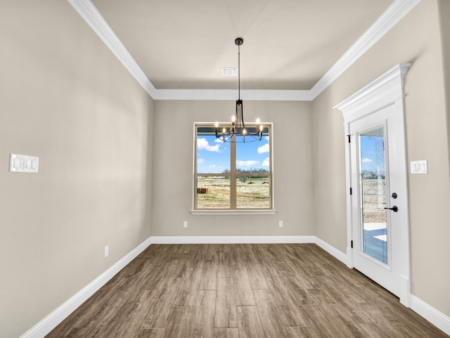 unfurnished dining area with dark hardwood / wood-style flooring, crown molding, and a chandelier