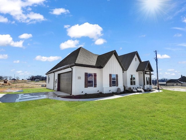 modern farmhouse featuring a front yard and a garage