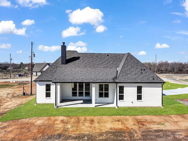 back of house with a patio and a lawn